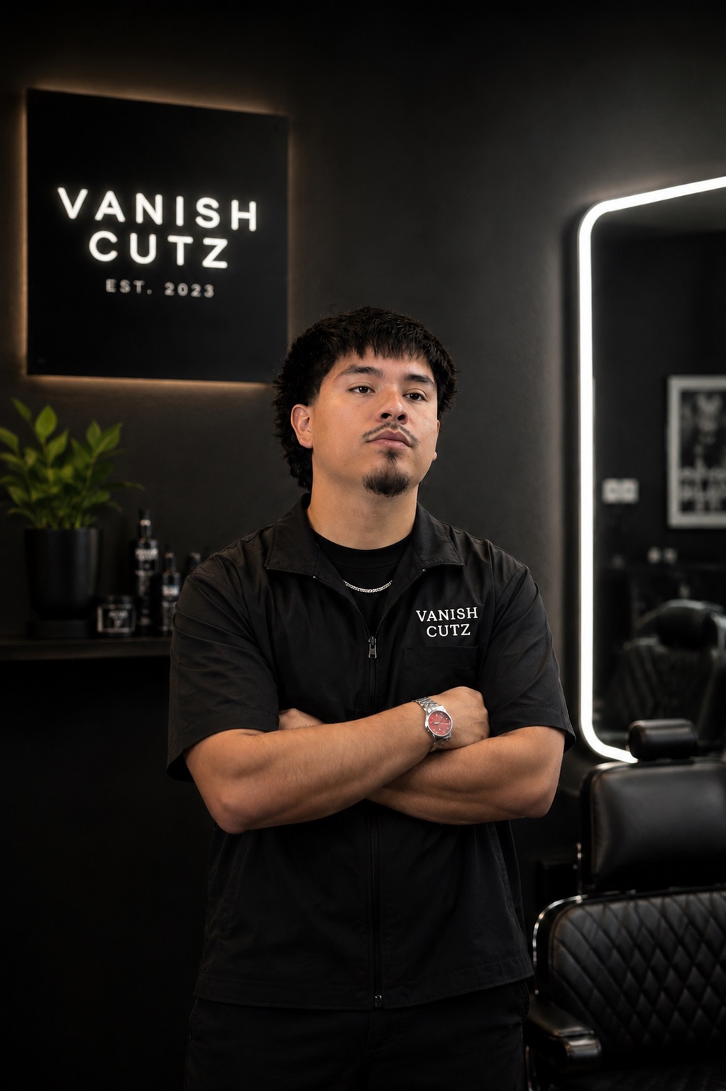 Barber standing in front of the Vanish Cutz sign at the studio