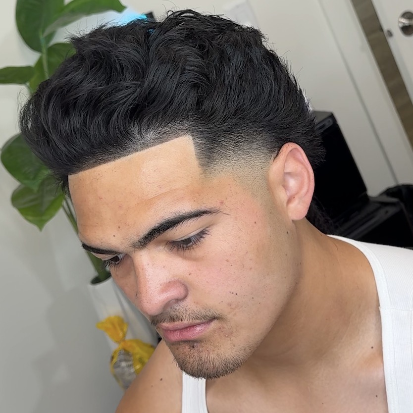Wavy textured taper haircut with sharp line-up and fade